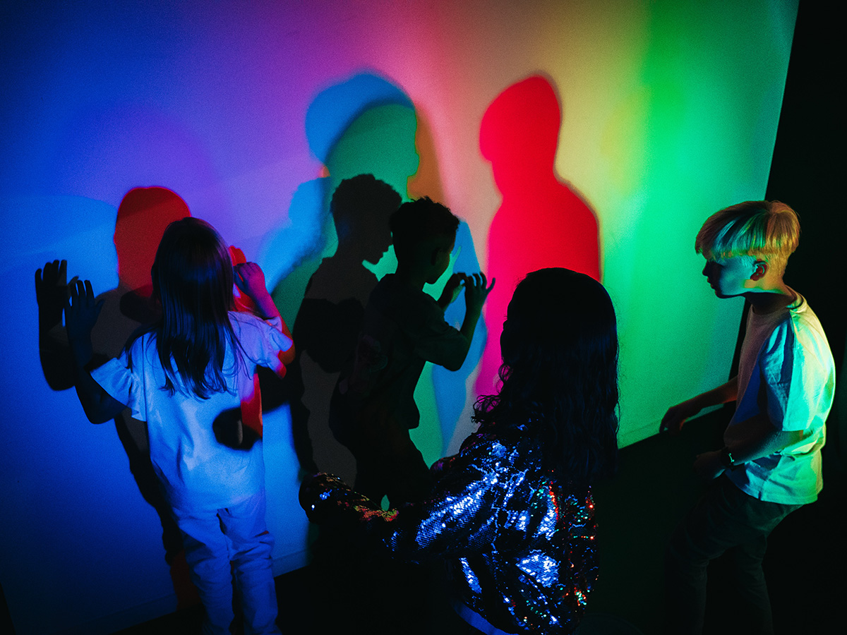 School children are interacting with their colourful shadows in the Colour Room.