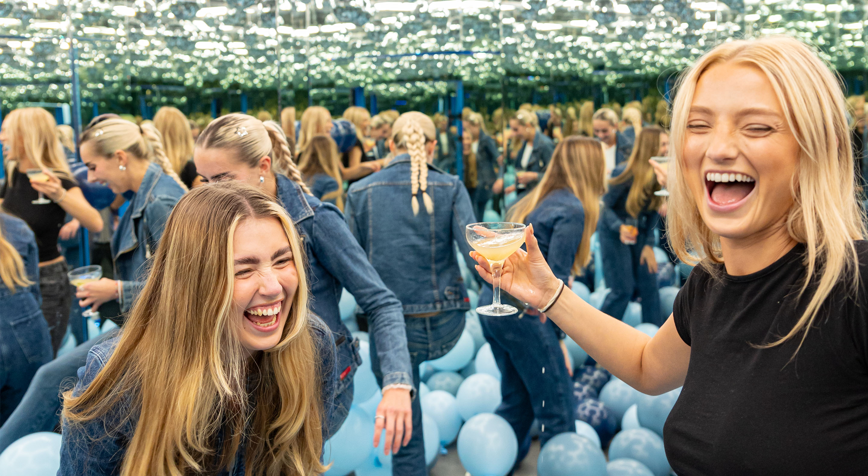 Young women are having fun while drinking cocktails in a balloons-filled Infinity Room at Museum of Illusions.
